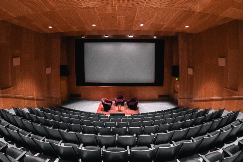 A panoramic view of Sound and Vision Theatre with three brown seats empty on the stage
