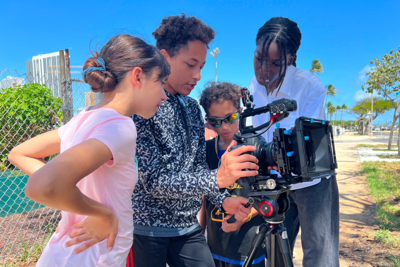 Four kids filming outdoors