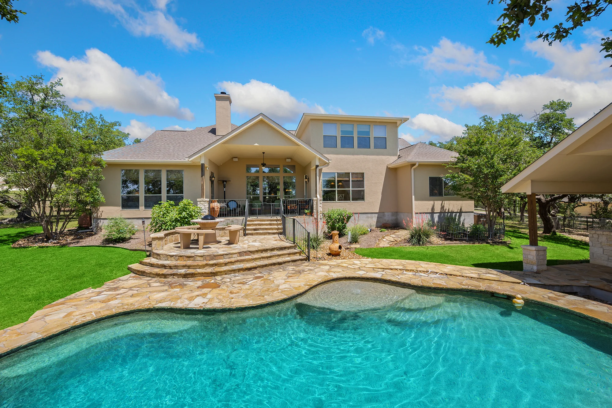 An outdoor covered patio with grills and refrigerators