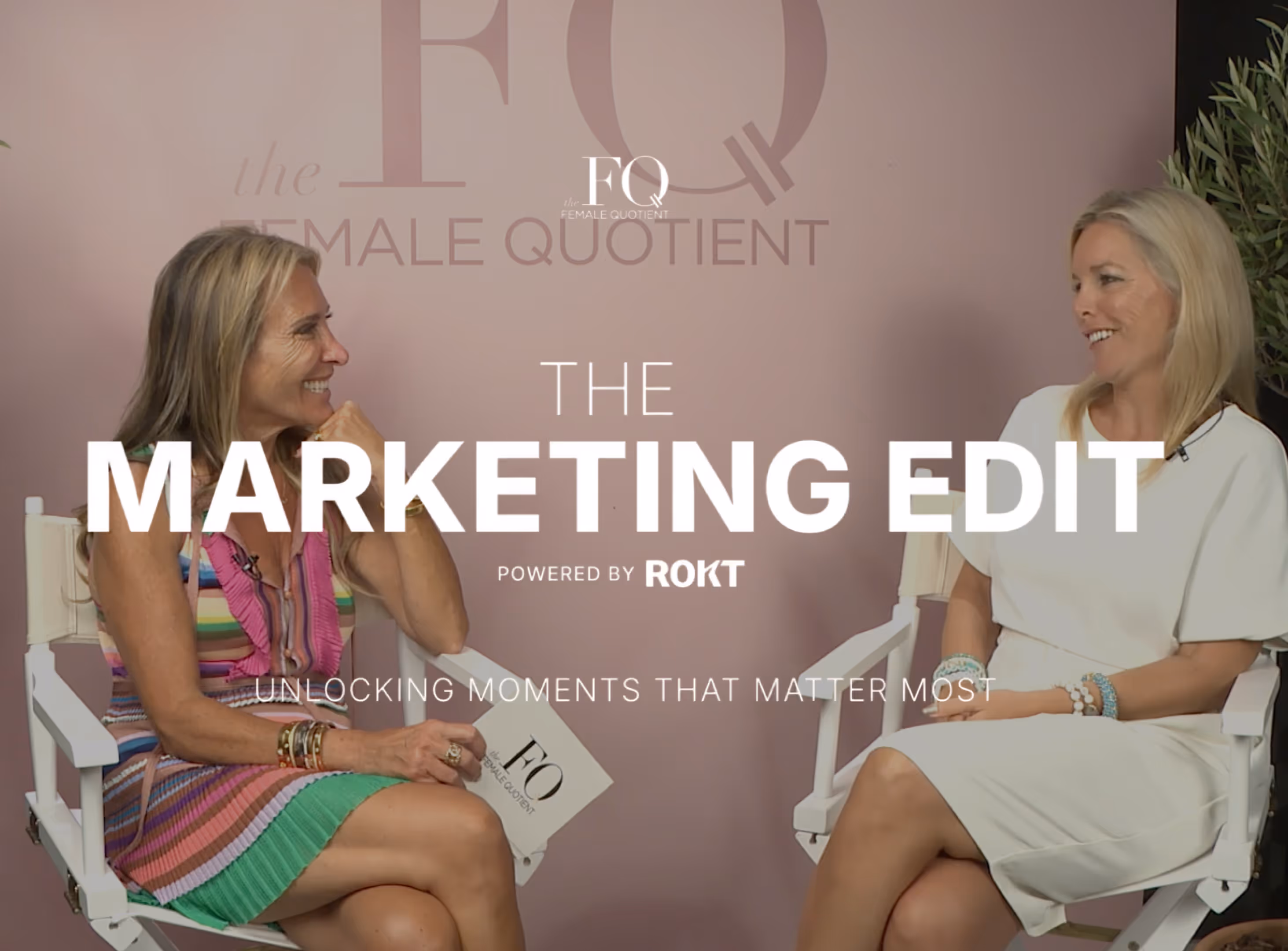 Two women talk in director’s chairs during The Marketing Edit, set against a pink Female Quotient backdrop.