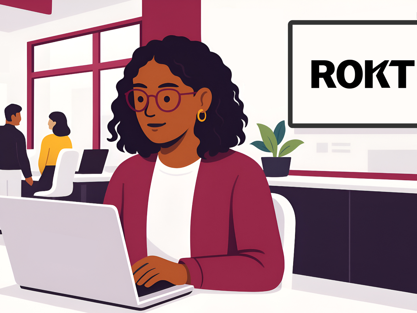 Illustration of a woman with curly hair and glasses working on a laptop in a modern office setting. She wears a maroon cardigan and gold hoop earrings. Behind her, a wall-mounted screen displays the Rokt logo in bold black text. A potted plant sits on a co