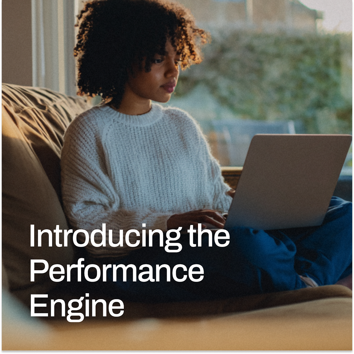 A young woman with curly hair works on a laptop on a couch by a sunlit window, with the headline “Introducing the Performance Engine” overlaid in white text.