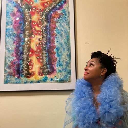 Teresa Vazquez in a blue tulle robe looking up at her piece #Antibody:Infiltrated