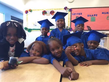 A picture of 8 kids in their graduation gowns