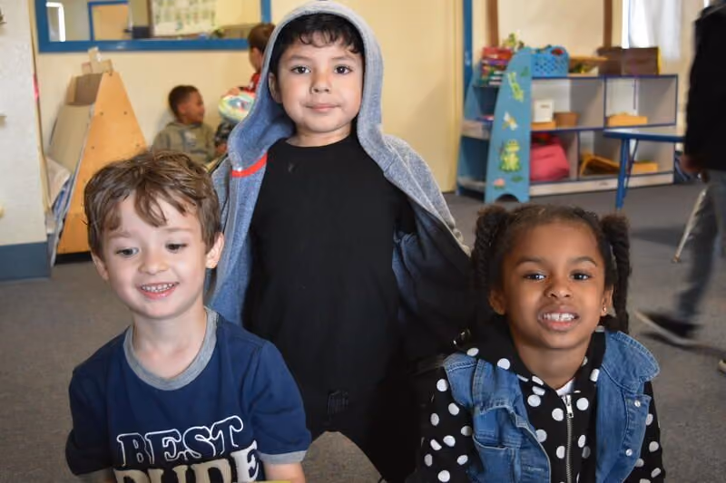 three kids smiling happily