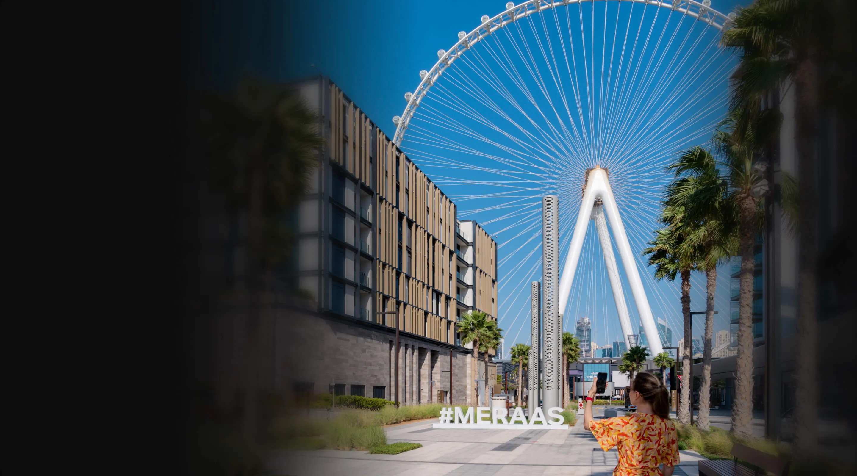 Bluewaters Island in Dubai, The Ain Dubai view. A woman pointing iPhone towards the building.