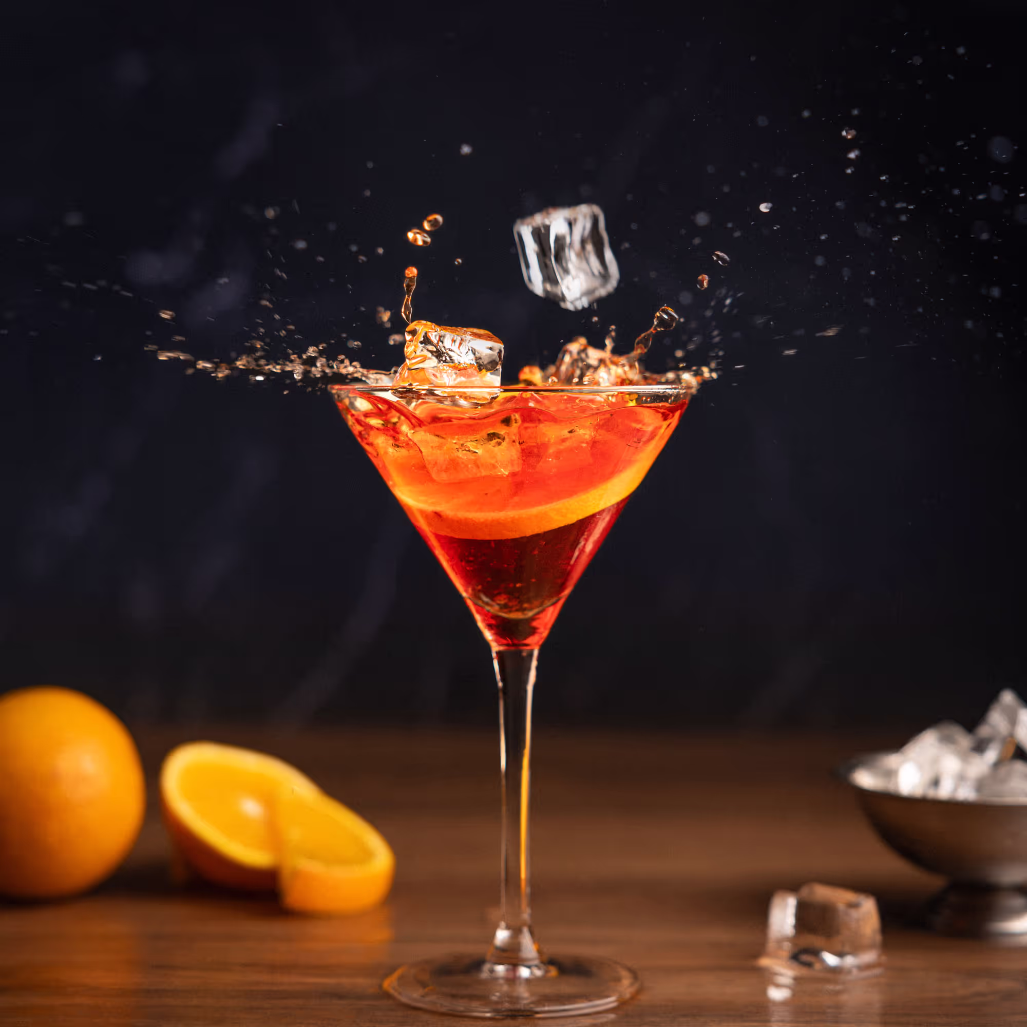 Un cocktail vibrant avec des glaçons en chute, éclaboussant la surface.