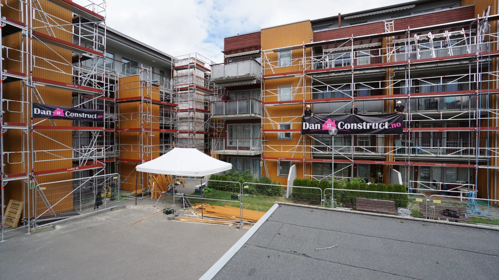 Ny fasade på boligblokk på Lunden i Oslo, med DAN Construct-banner på stillaset