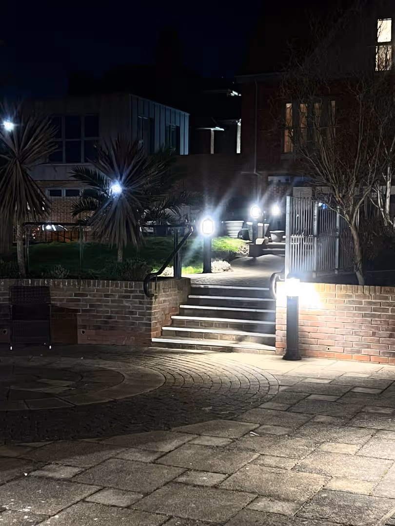 Staircase with bright lights leads to a building entrance at night.