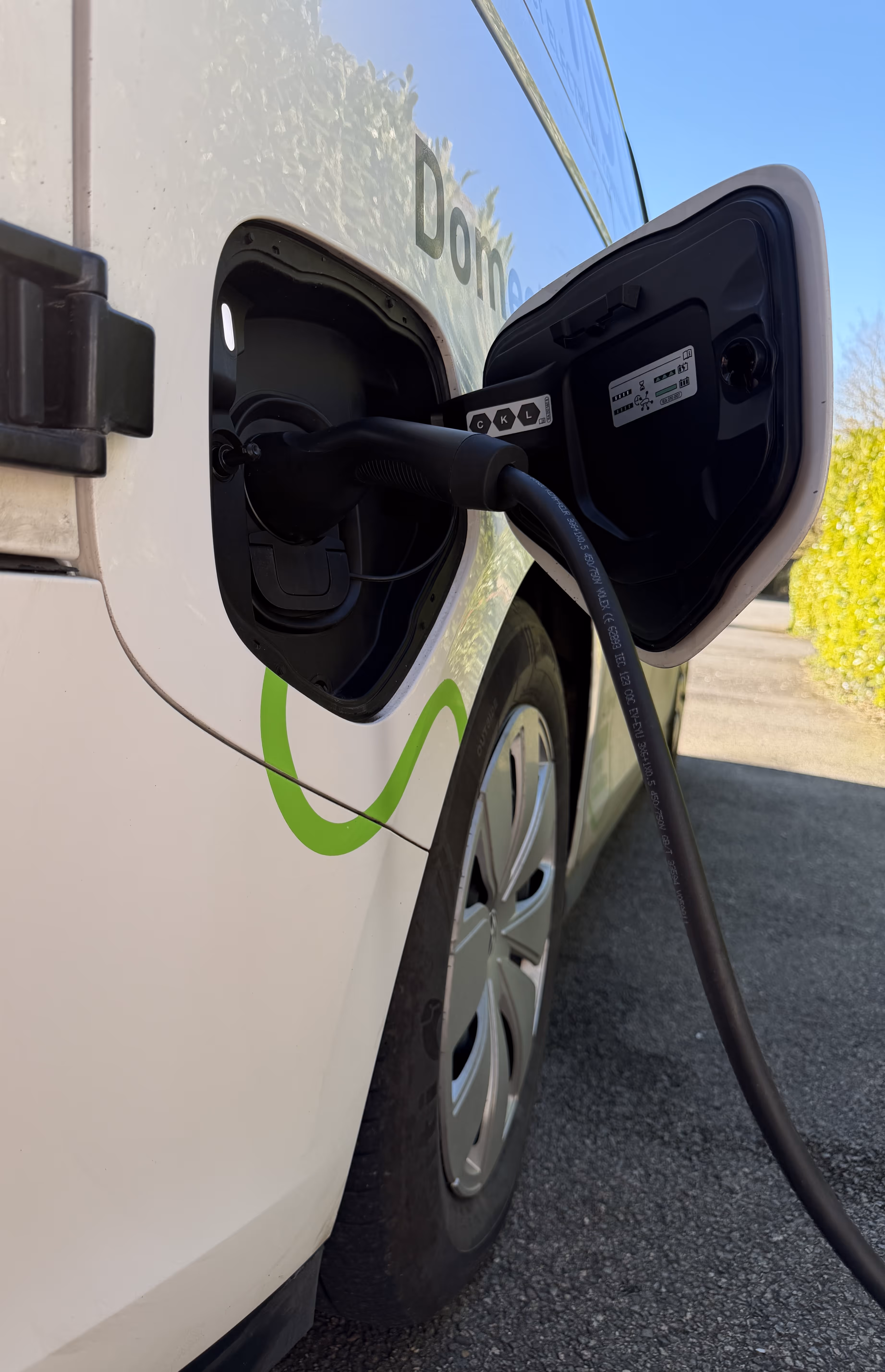 An electric car is plugged into a charging station for recharging.
