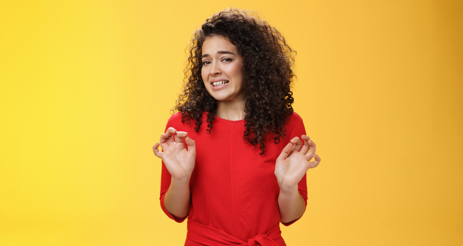 A woman with a red shirt in front of a yellow background has a disturbed look on her face, holding her hands closer to her, reacting to the question, "Should I copy and paste a privacy policy?"