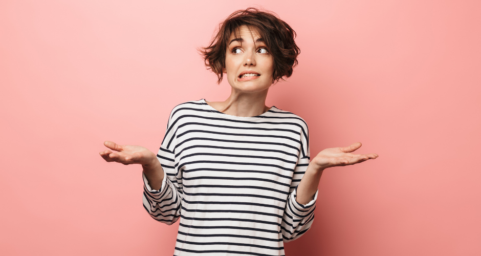 A woman with a black and white striped shirt shrugging with a questioning look on her face, asking "What's included in a standard privacy policy?"
