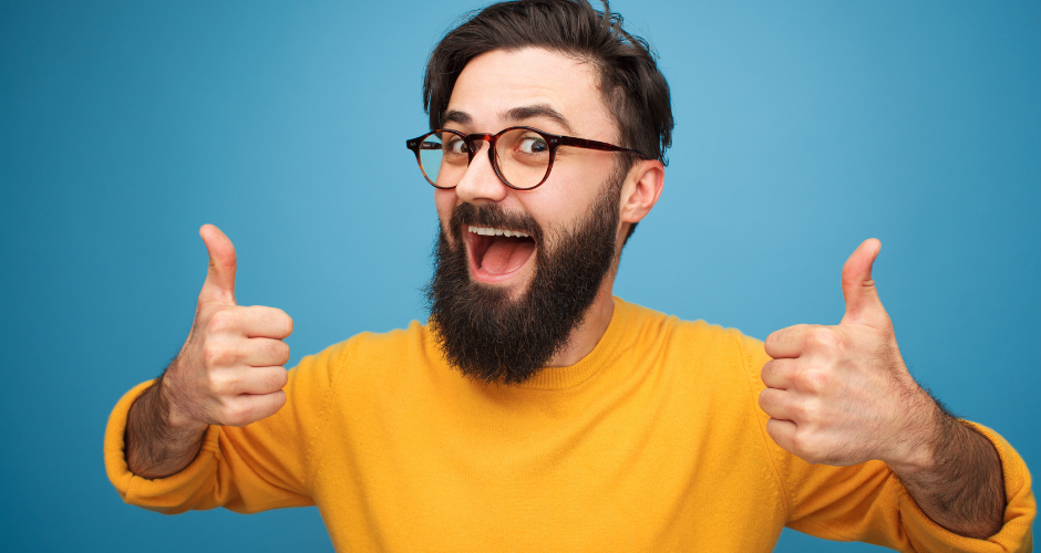 A happy smiling man with a yellow shirt in front of a blue background has both thumbs up, reacting to the question, "Should I use a privacy policy template?"