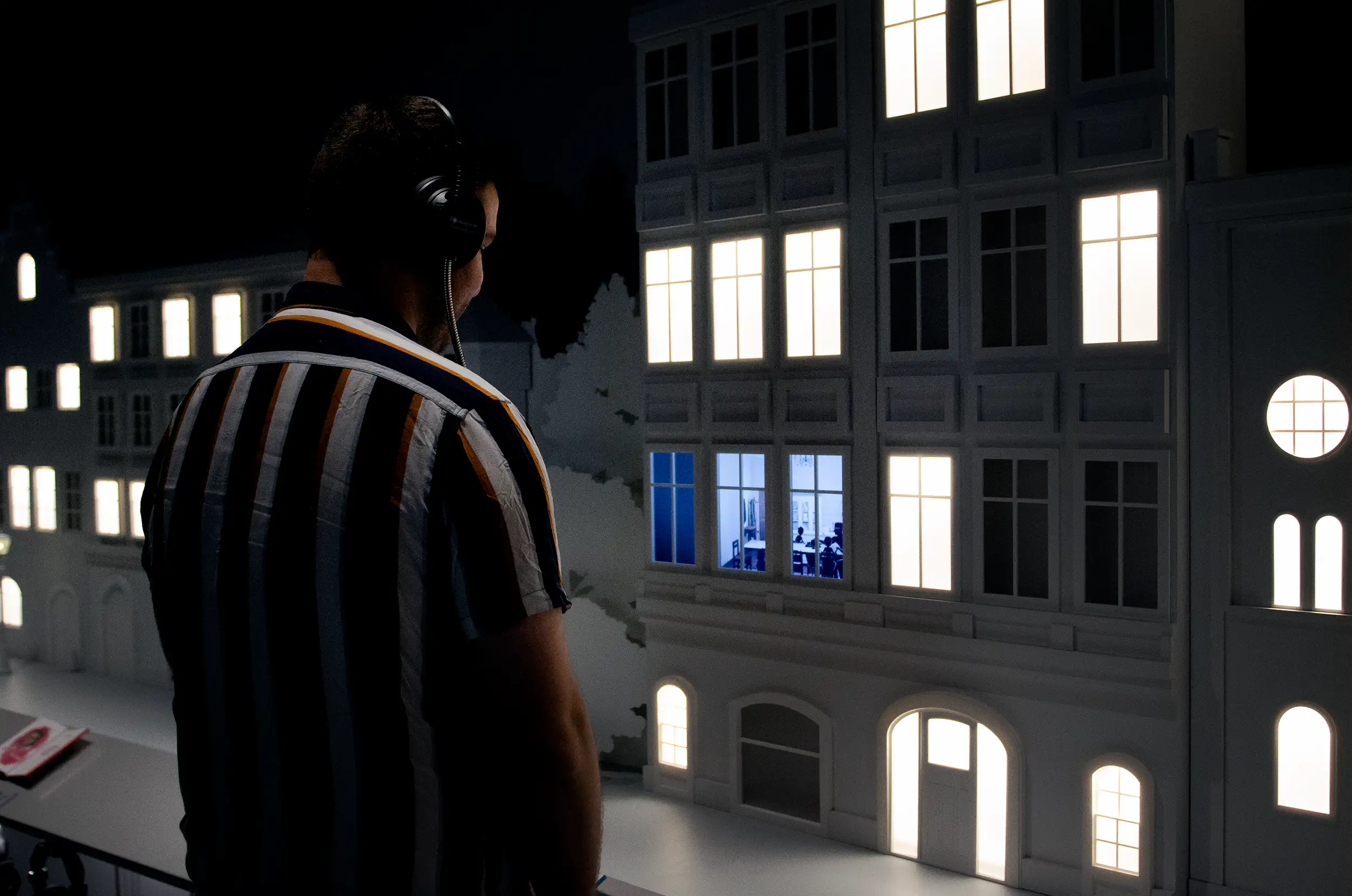 A visitor looking at an animation playing through the window of a mini village