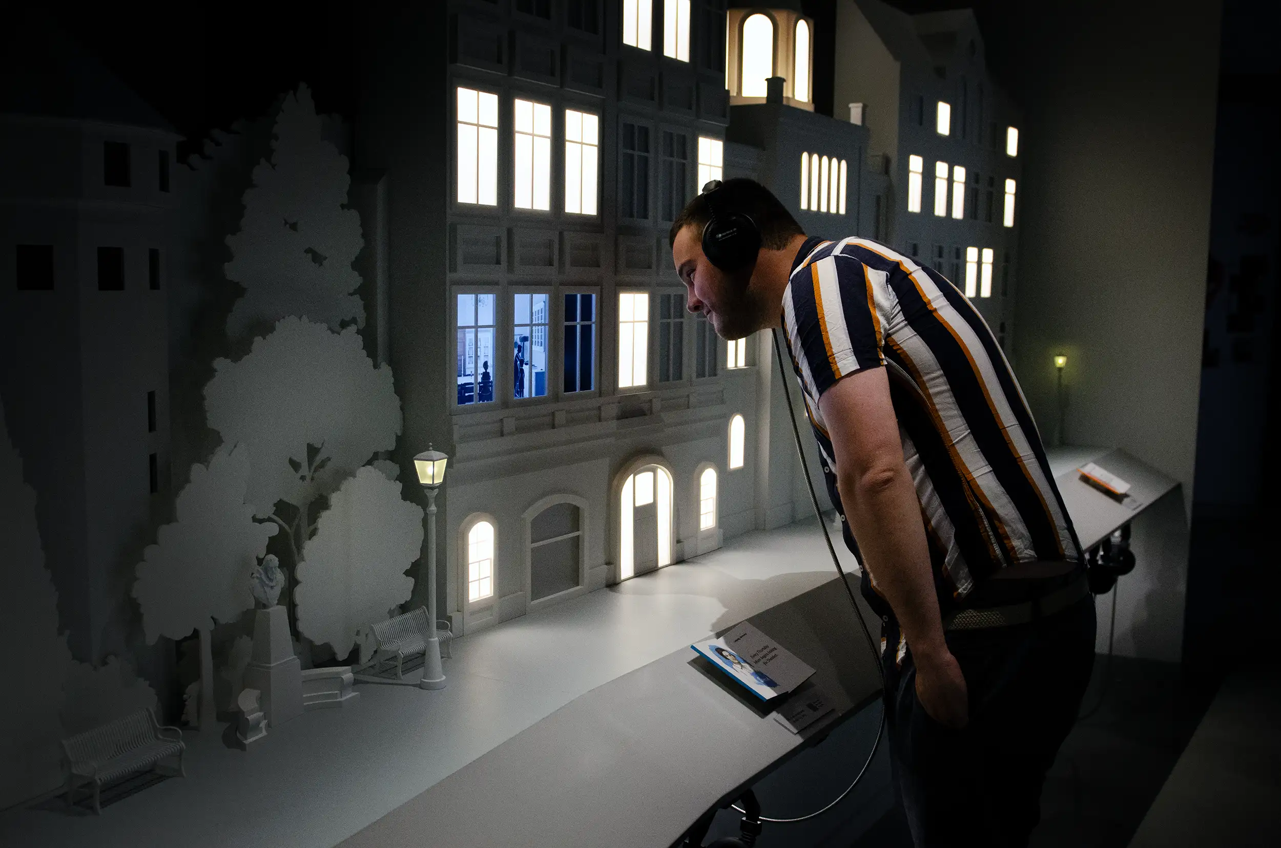 Visitor wearing headphones leaning in to watch animated story