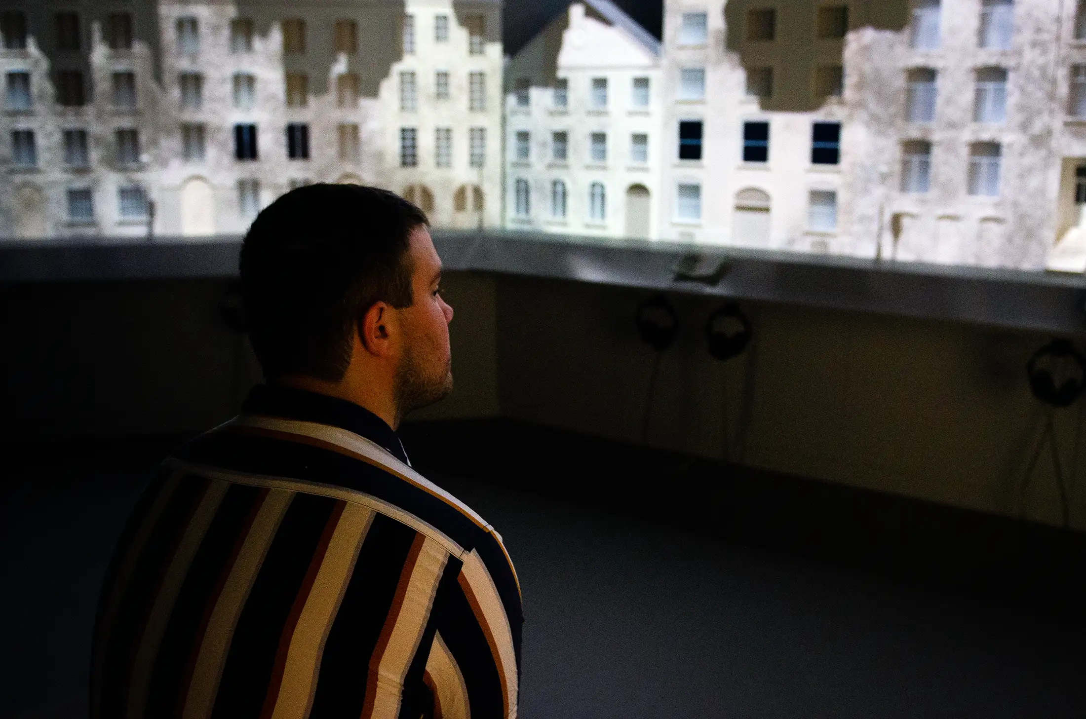 A visitor looking at projection mapping animations on top of a miniature village.