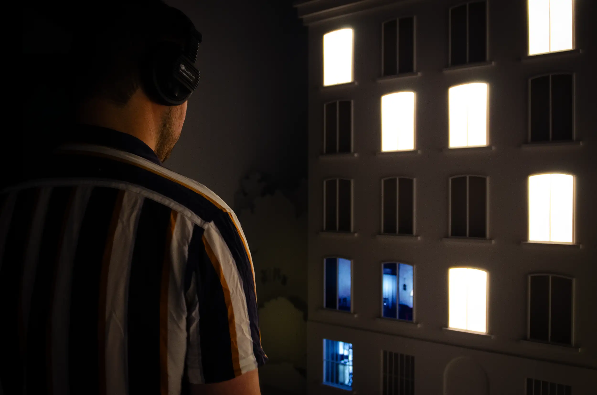 A male visitor looking at an animation playing through the window. 