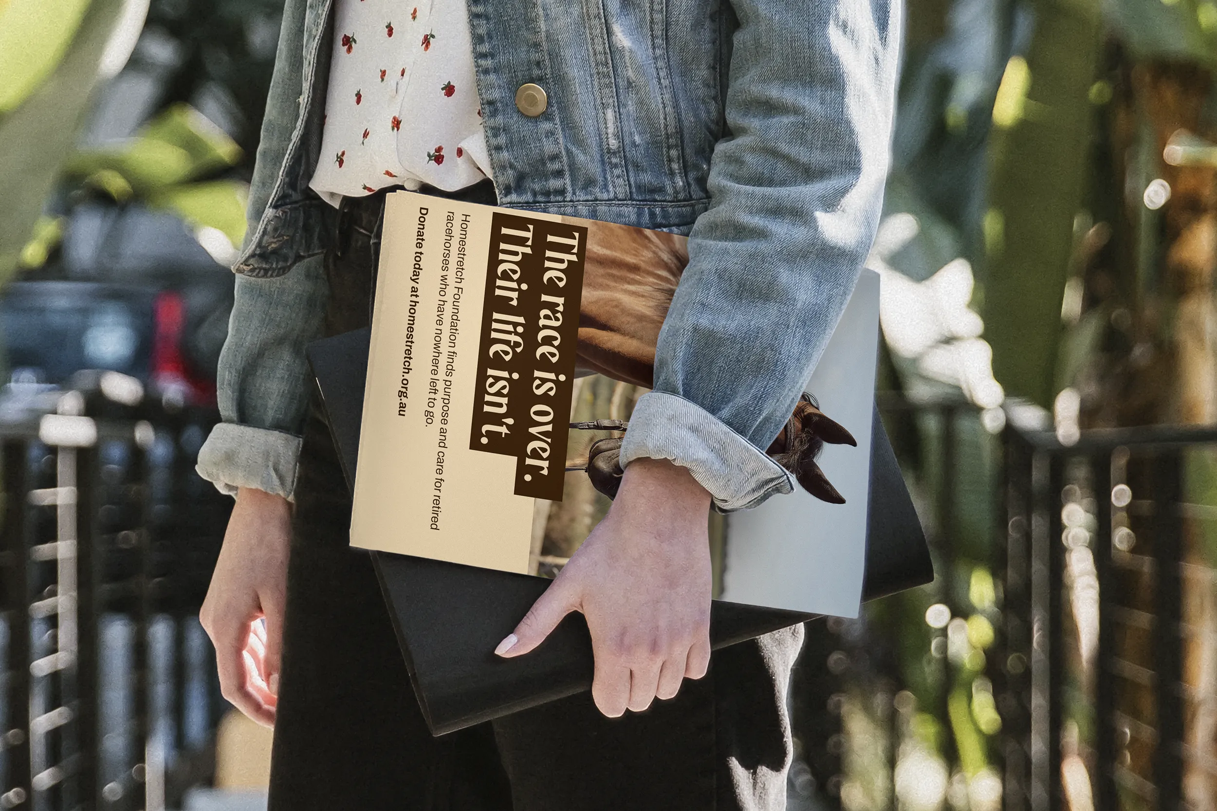 Person carrying a flyer with a photo of a horse, and text asking people to donate