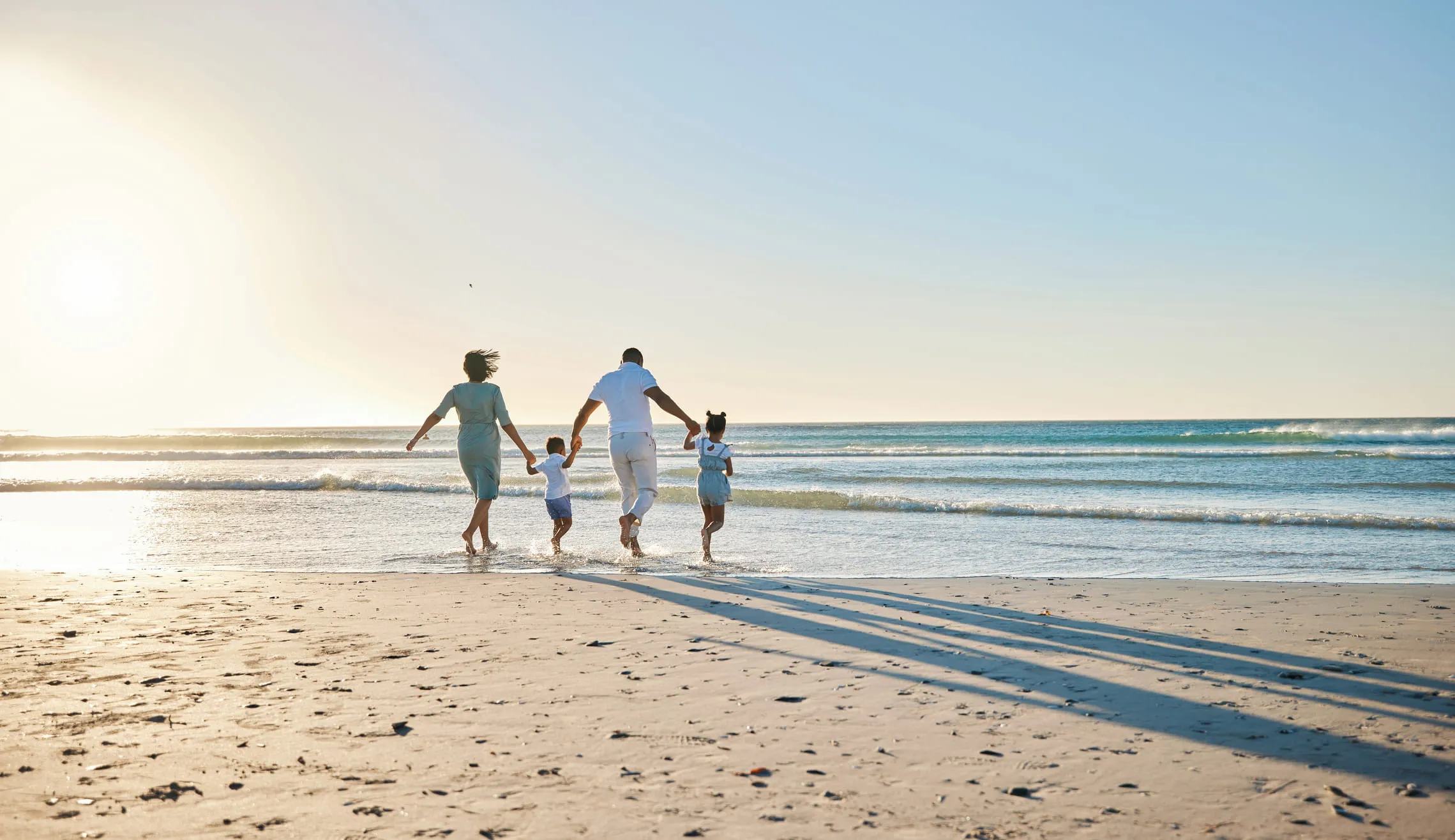 family walking down the shoreline
