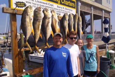 a family standing near fish they caught