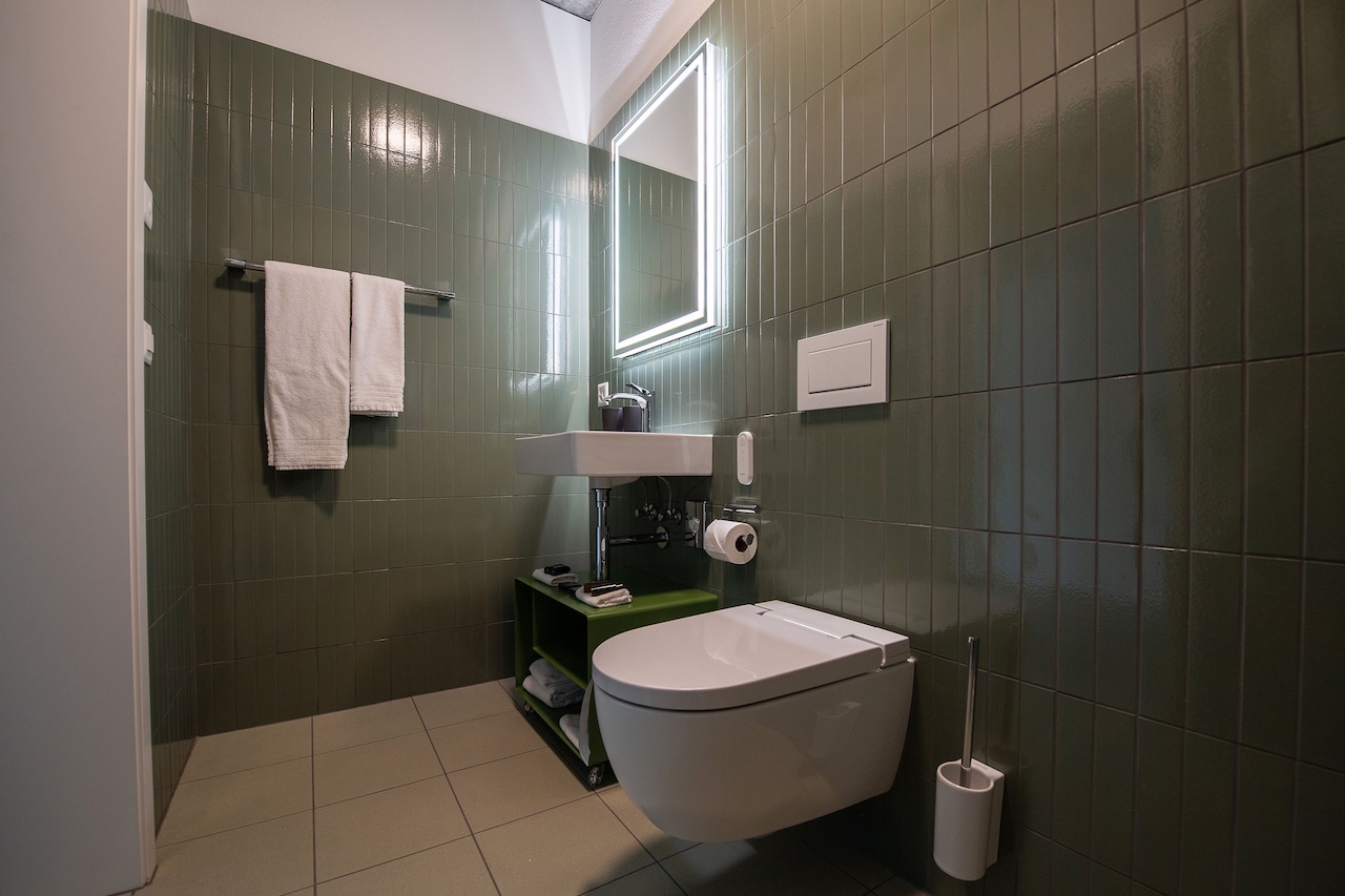 Das moderne Badezimmer im Aparthotel Il Momento überzeugt durch schlichte Eleganz und hochwertige Ausstattung. Für besonderen Gästekomfort sorgt das AquaClean Alba Dusch-WC.