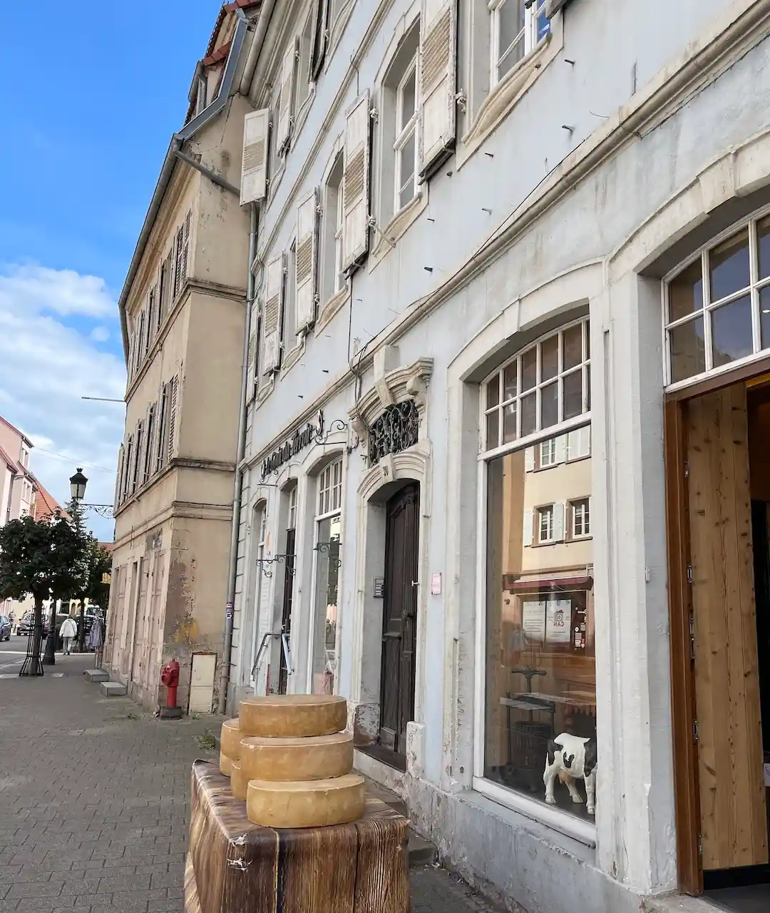 Kleine Häuser im Elsass. Vor einem stehen Käselaiber auf einem Regal