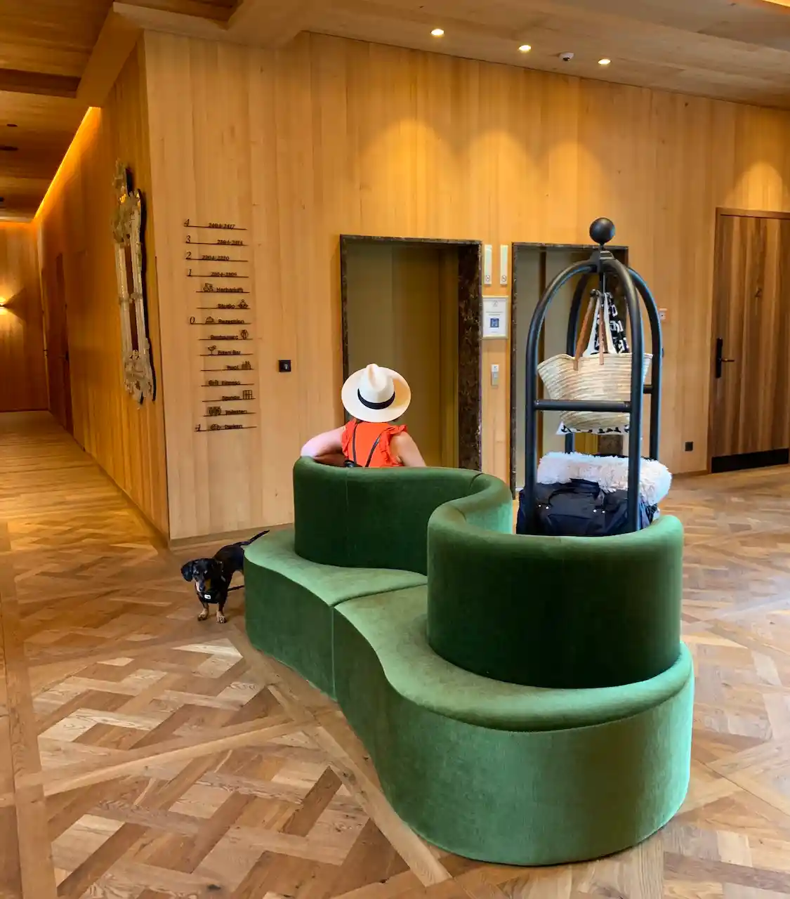 Empfangsbereich im MalisGarten: Frau auf einem grünen Sofa und Wände aus Holz