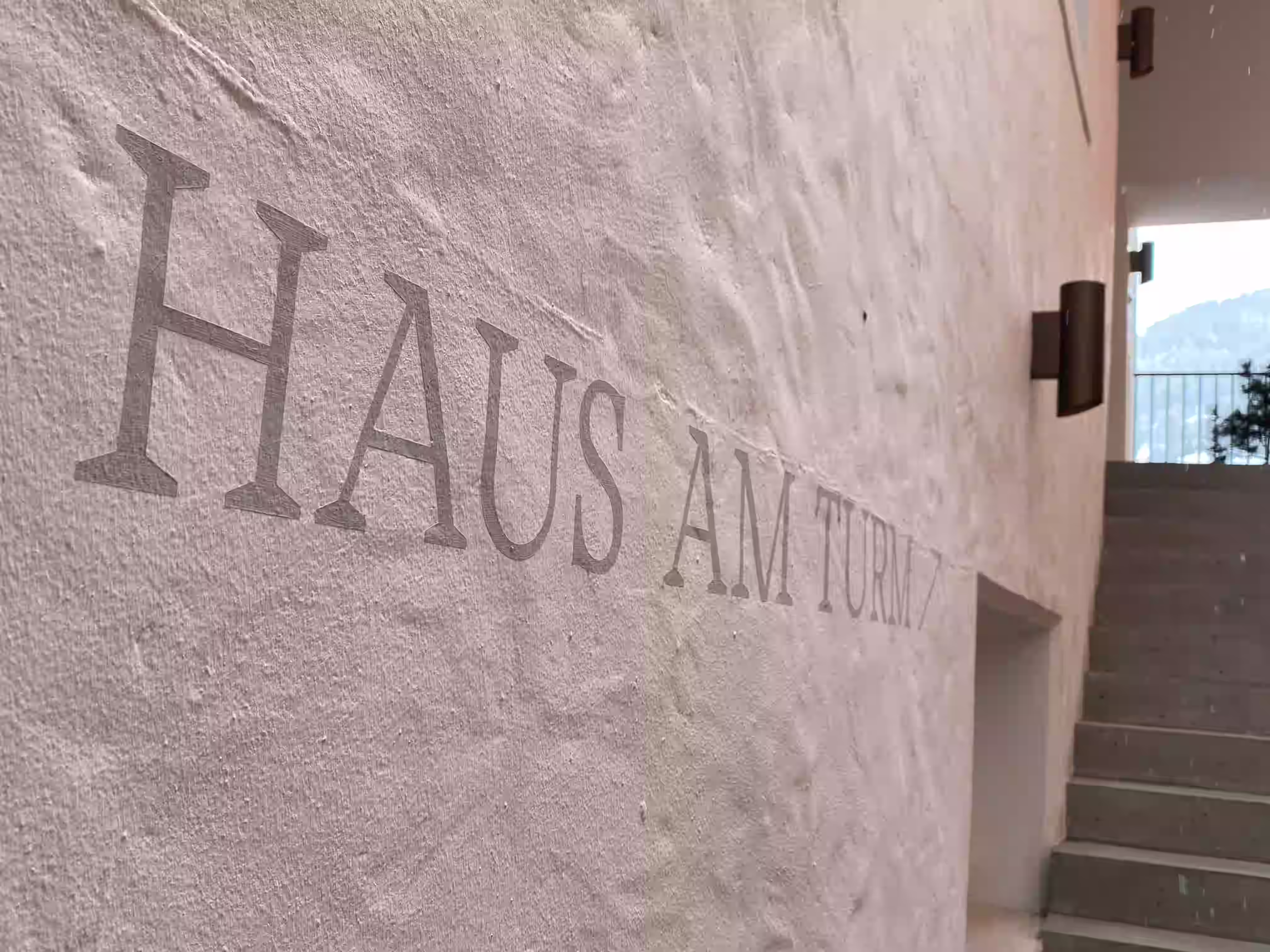 Haus am Turm Sterzing – Schriftzug „Haus am Turm" auf weiß verputzter Wand am Hoteleingang