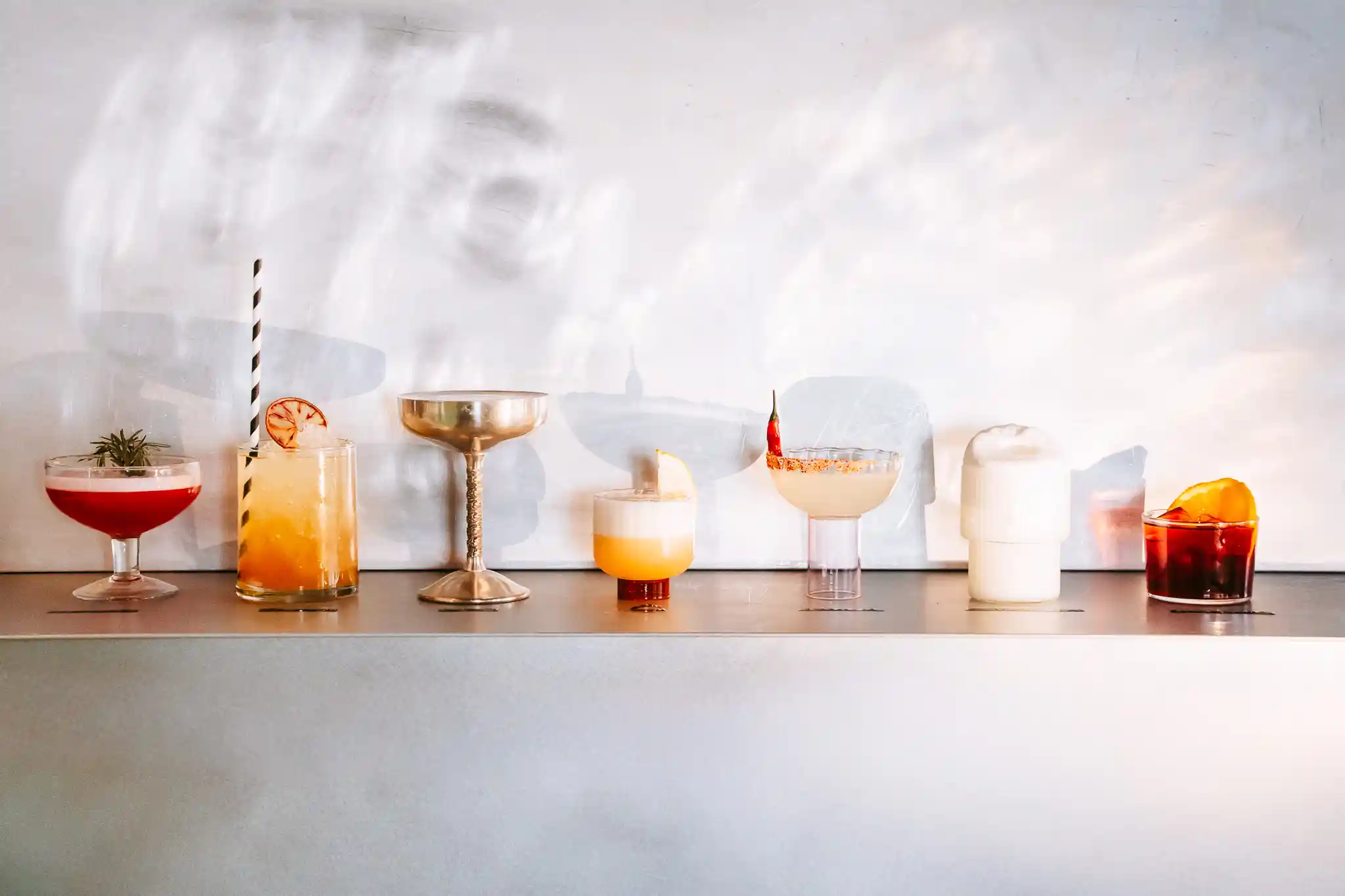 Lecker! Sieben in der Reihe aufgestellte Drinks bzw. Cocktails aus der Bar im Hotel Seebichl
