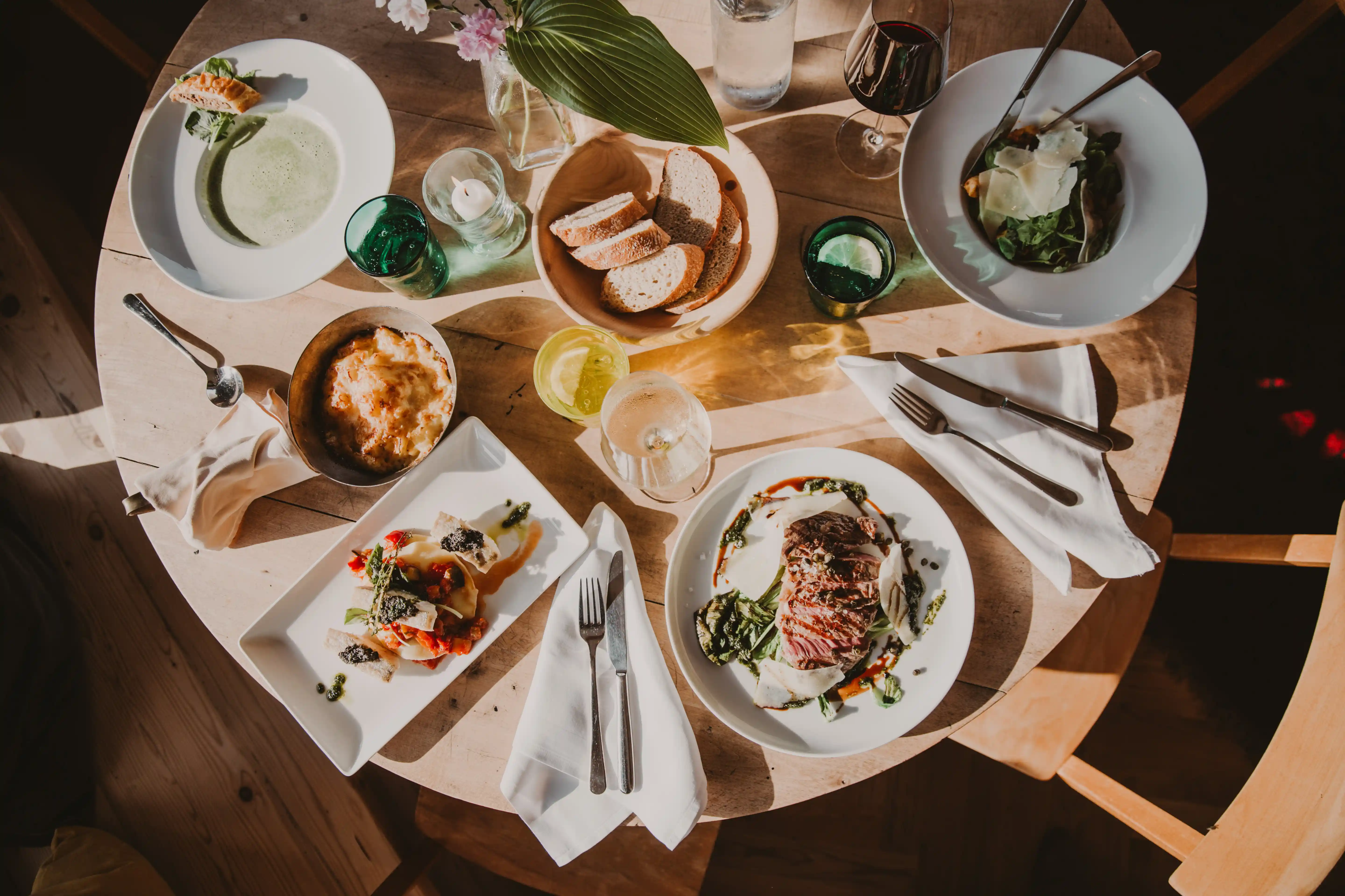Gedeckter runder Tisch im Seebichl bei Kitzbühel mit Brot, Fleisch, Salat etc.