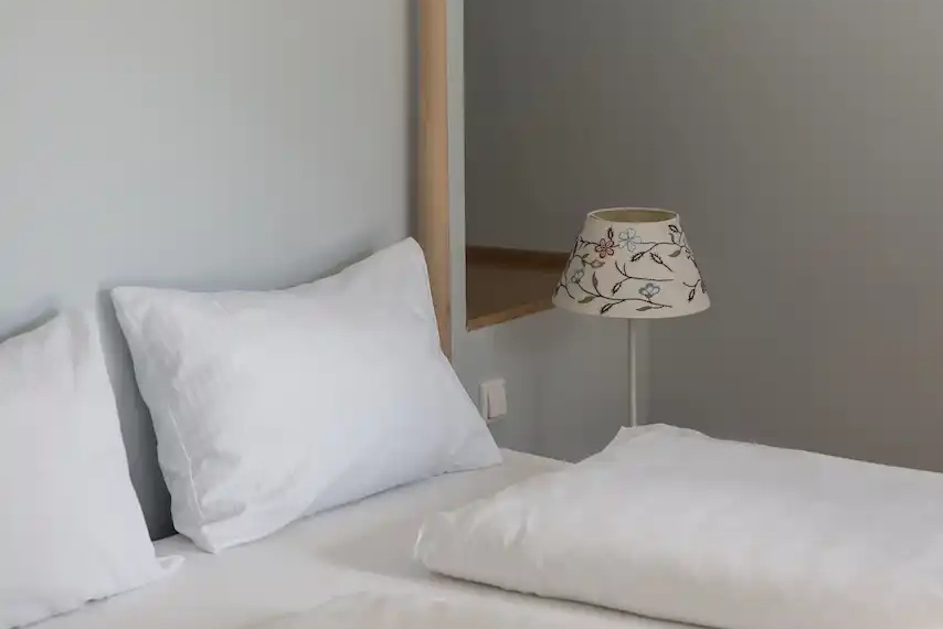 Bett mit weißen Laken im Trinserhof Hotel