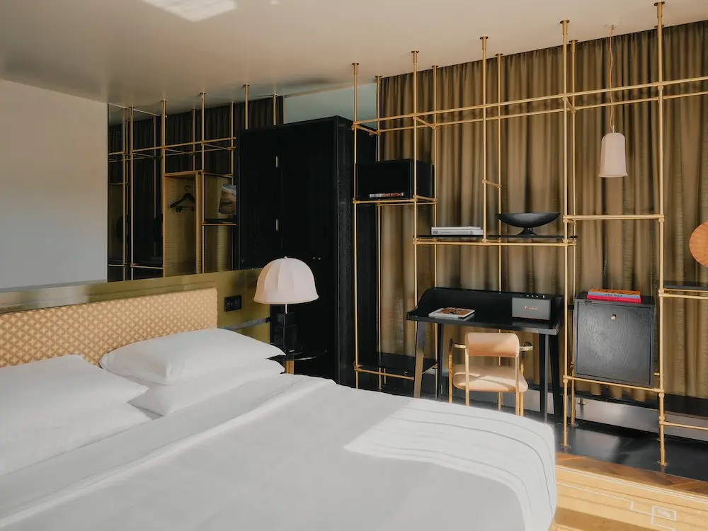 Deluxe Suite im The Dean Munich: Bett vor Regalwand mit Jugendstil-Elementen