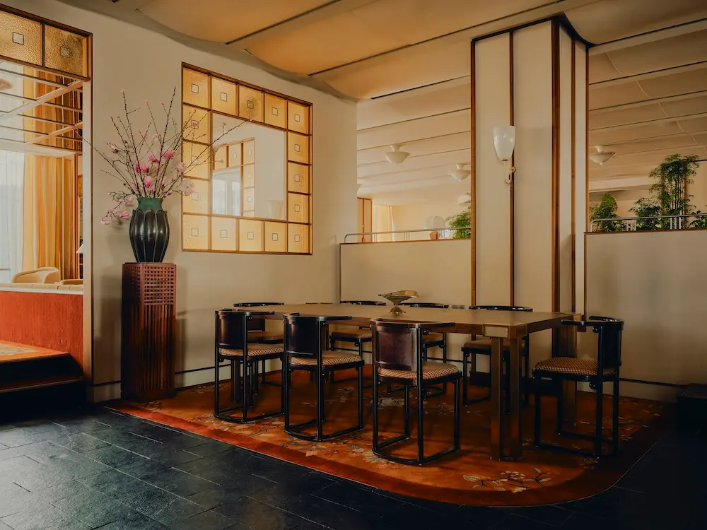 Jugendstil Holztische mit 8 Stühlen auf rotem floralem Teppich im Ibasho Restaurant im The Dean Hotel Munich