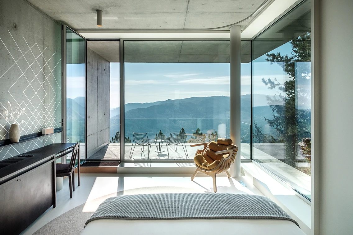 Design-Hotelzimmer im Casa de São Lourenço mit bodentiefen Panoramafenstern und weitem Blick auf die Berge.