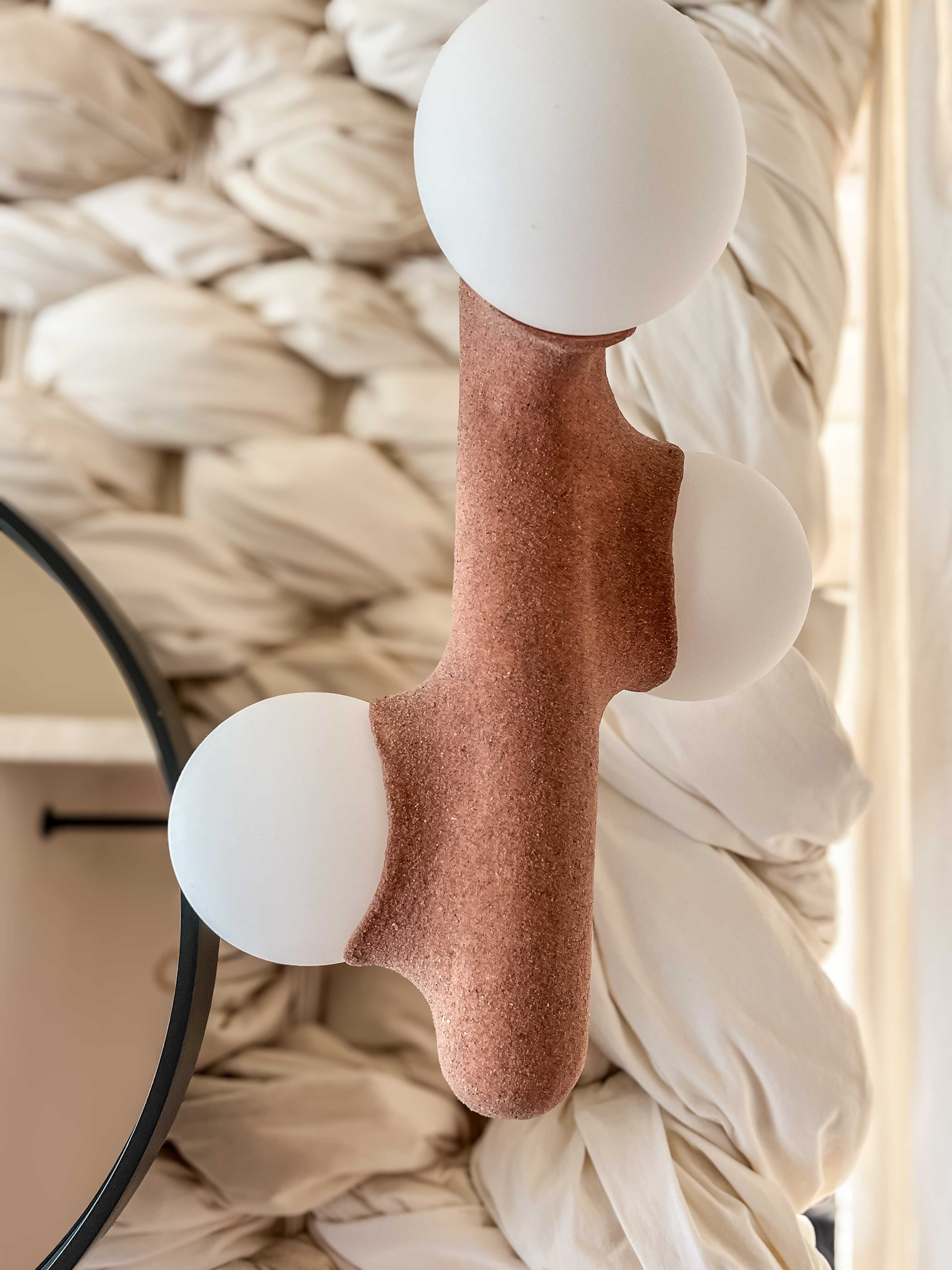 Skulpturale Wandleuchte aus rotem Terrakotta-Guss mit drei kugeligen Glaskörpern im Son Blanc Farmhouse Menorca.