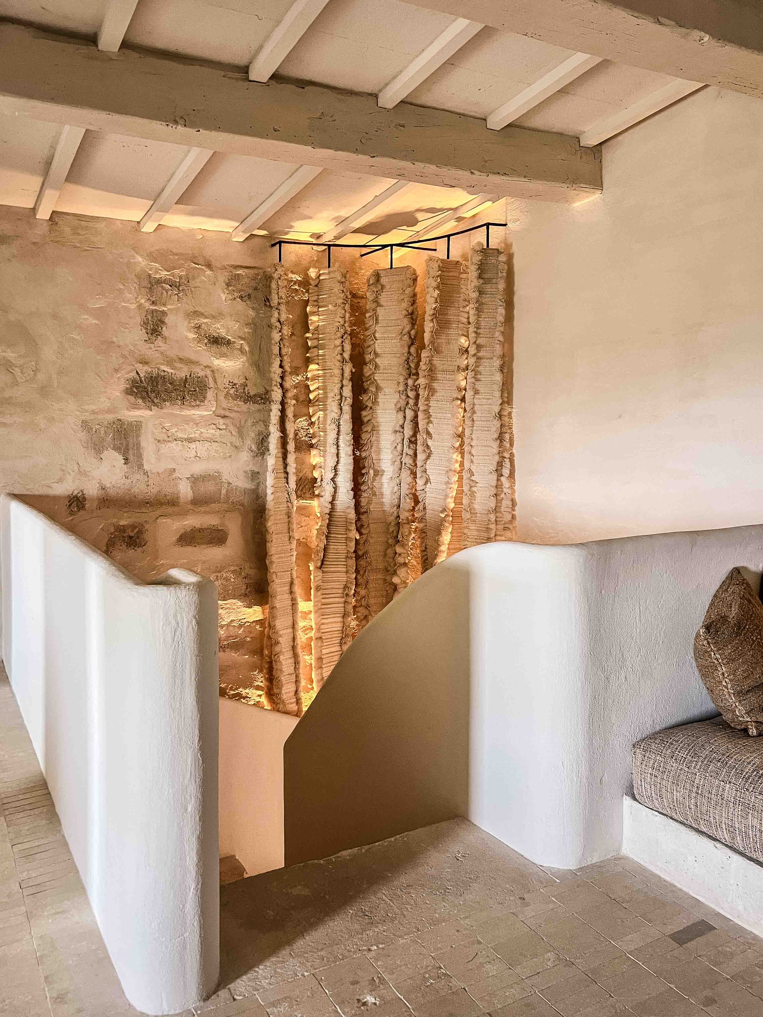 Hinterleuchtete Naturfaser-Textilinstallation im weiß geputzten Treppenaufgang des Son Blanc Farmhouse Menorca.