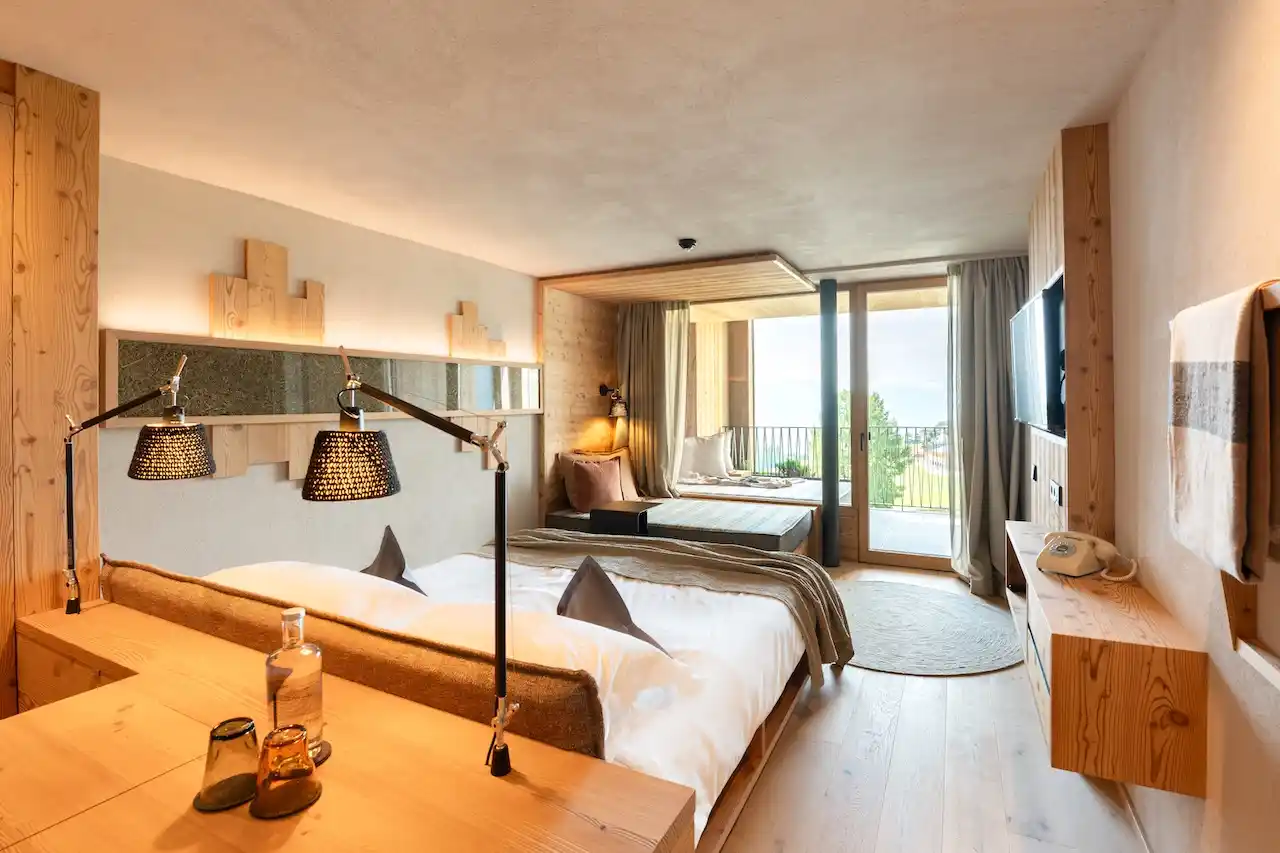 Suite im Biohotel Gitschberg in Meransen. Viel Holz, gemütliches Bett, Veranda