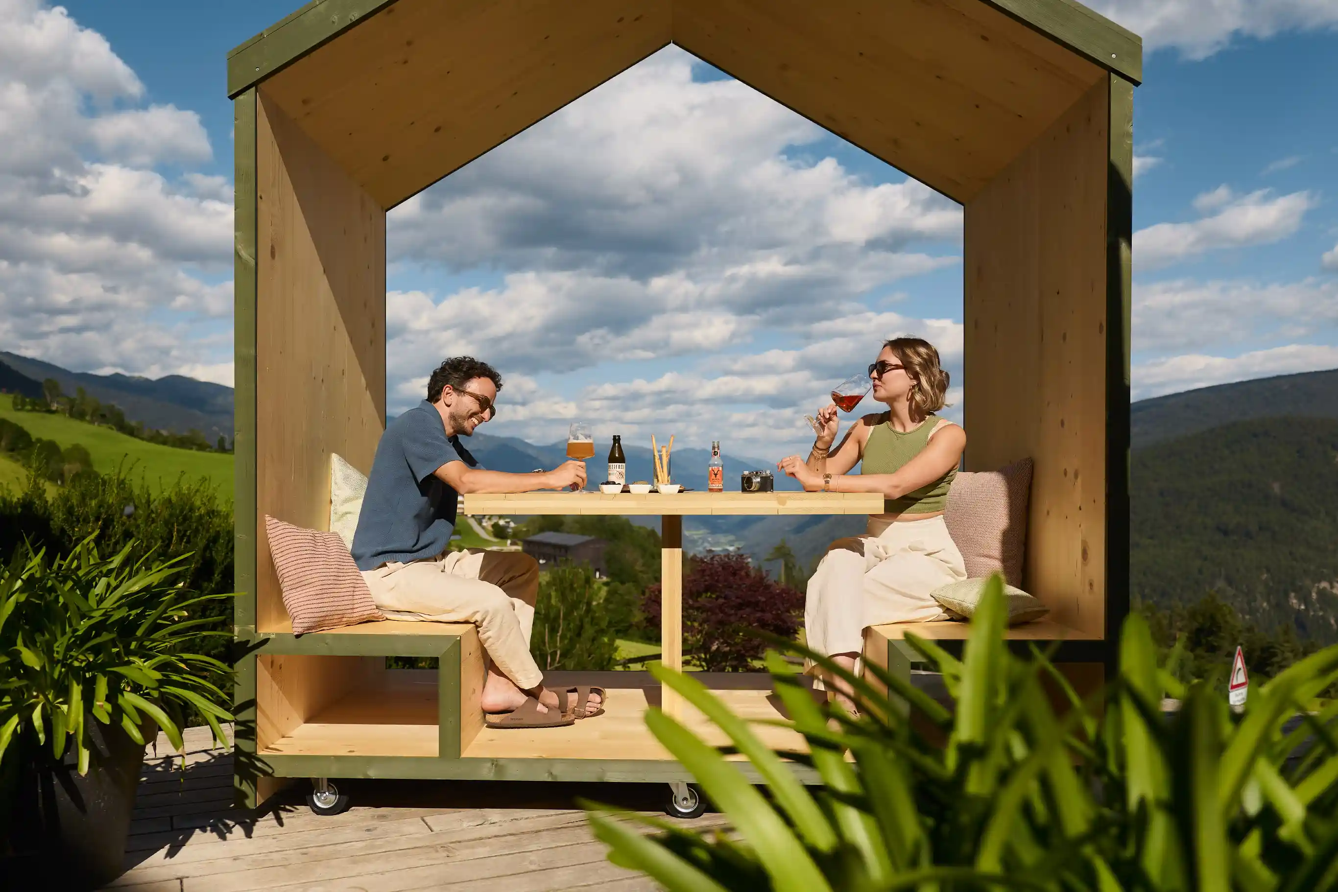 AUI Südtirol: Paar beim Essen unter Outdoor-Holzkonstruktion