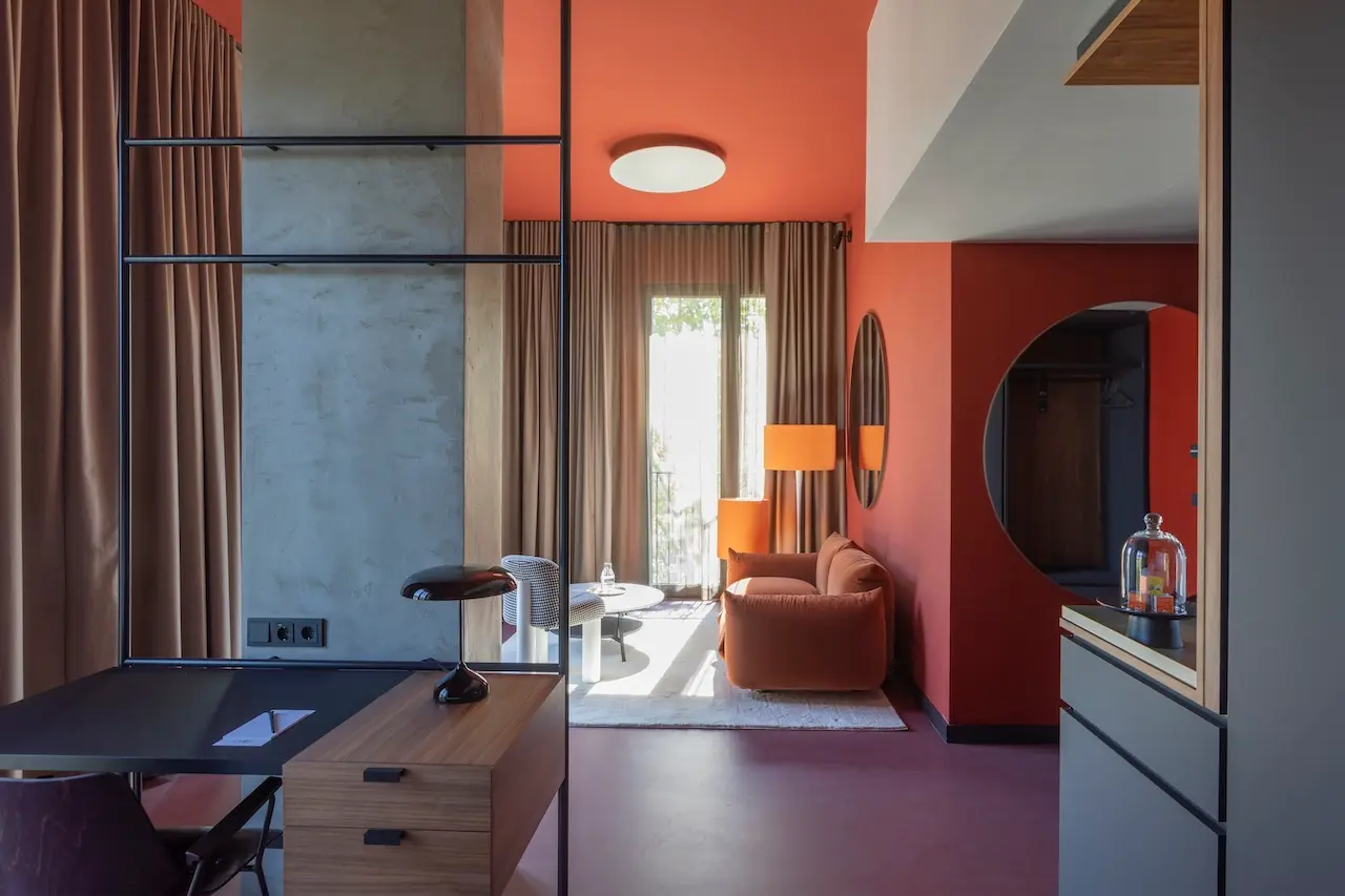 Suite im EMILU Hotel mit roter Wand und dunklen Vorhängen