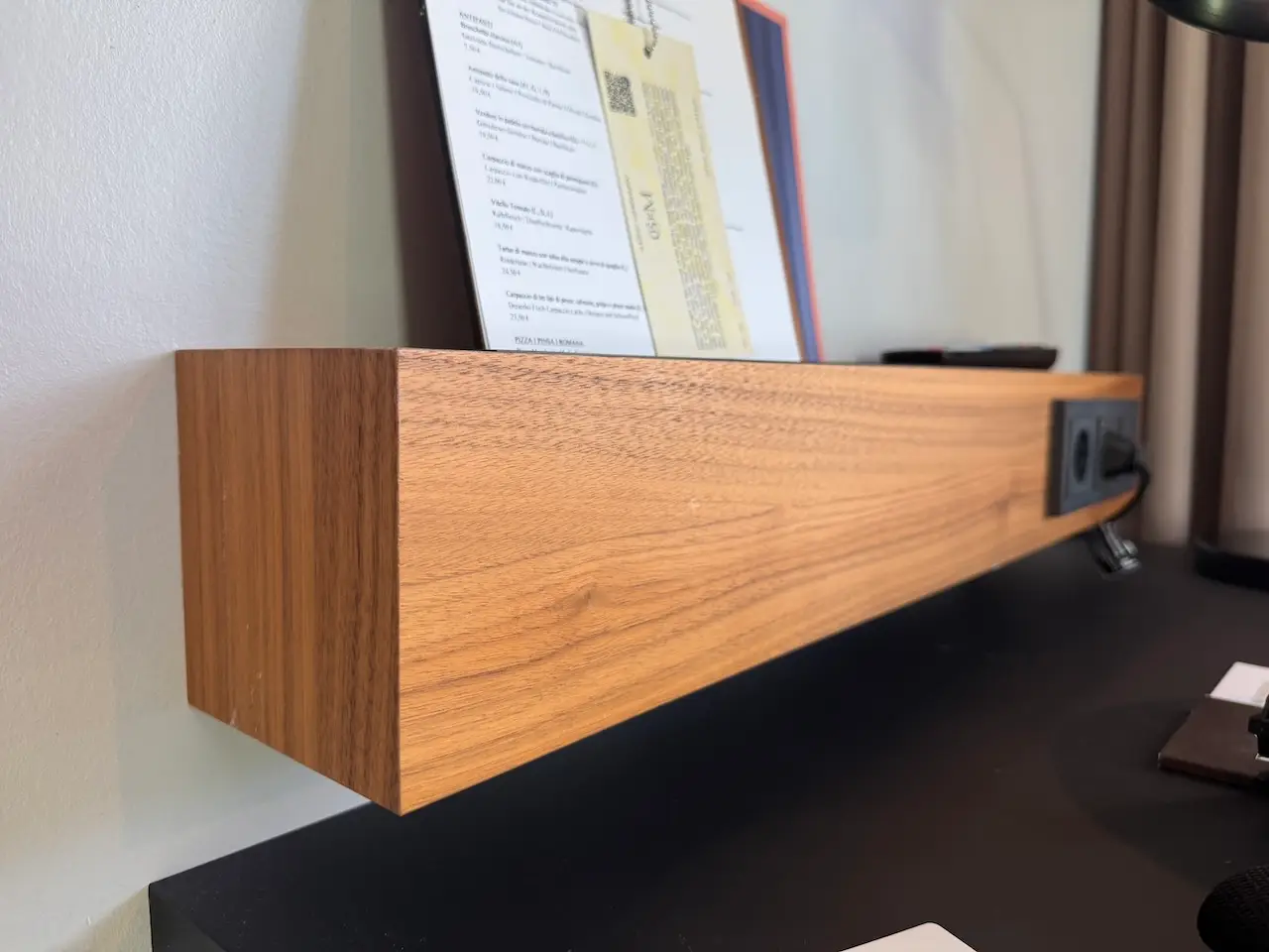 EMILU Hotel: Holzregal mit Steckdose über Schreibtisch