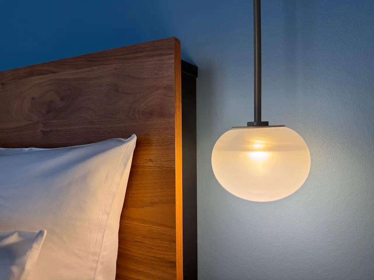 EMILU Hotel: Leuchte neben Bett und vor blauer Wand