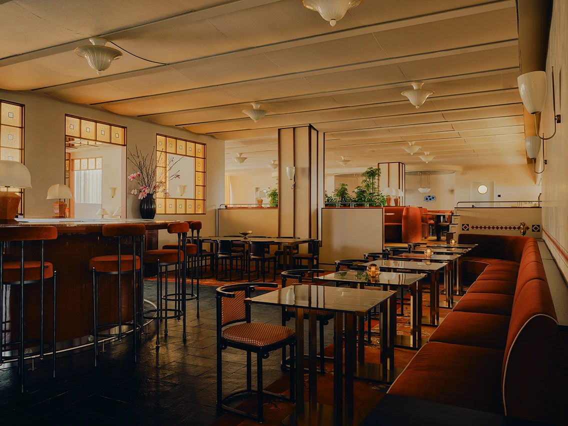 Großzügiger Speiseraum im Restaurant Ibasho mit rot gepolsterter Eckbank, Holzstühlen und warmer Beleuchtung im Hotel The Dean München