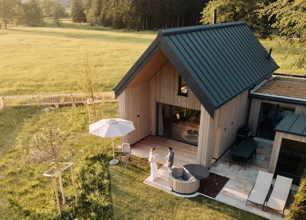 Agrad Chalets: Chalet aus der Vogelperspektive, dahinter Wiese || © Formgestalter