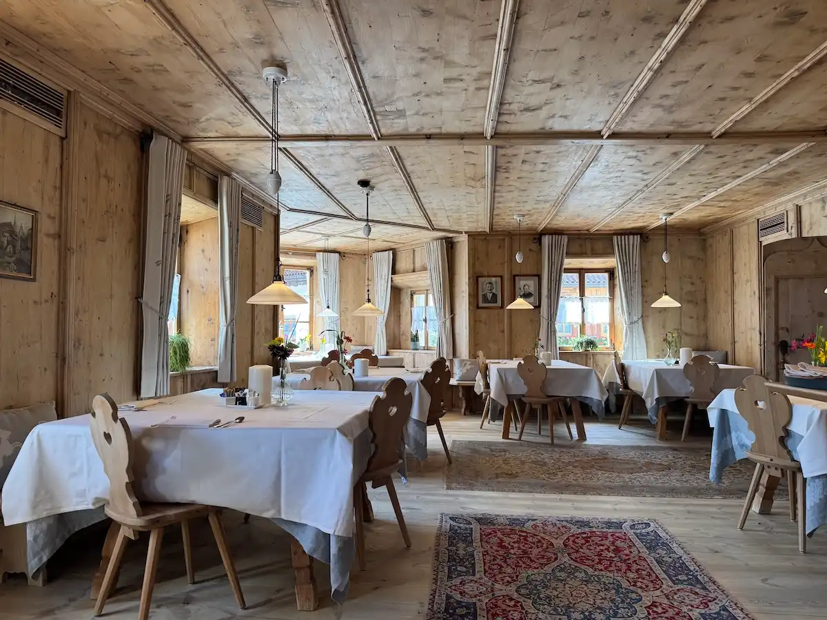 Ansitz Steinbock Südtirol: Restaurant mit Holzvertäfelung und alten Tischen sowie Stühlen aus Holz