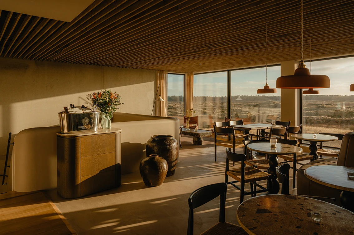 Gastraum des Restaurant Dún im Hotel Elements Terschelling mit stilvollen Holztischen, warmen Pendelleuchten und verglastem Panoramablick auf die Dünen. || © Chantal Arnts