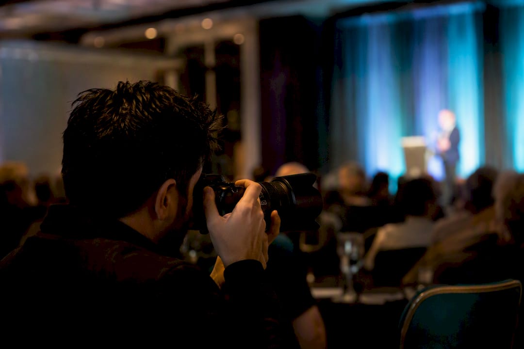 Photographer shooting keynote speaker during event