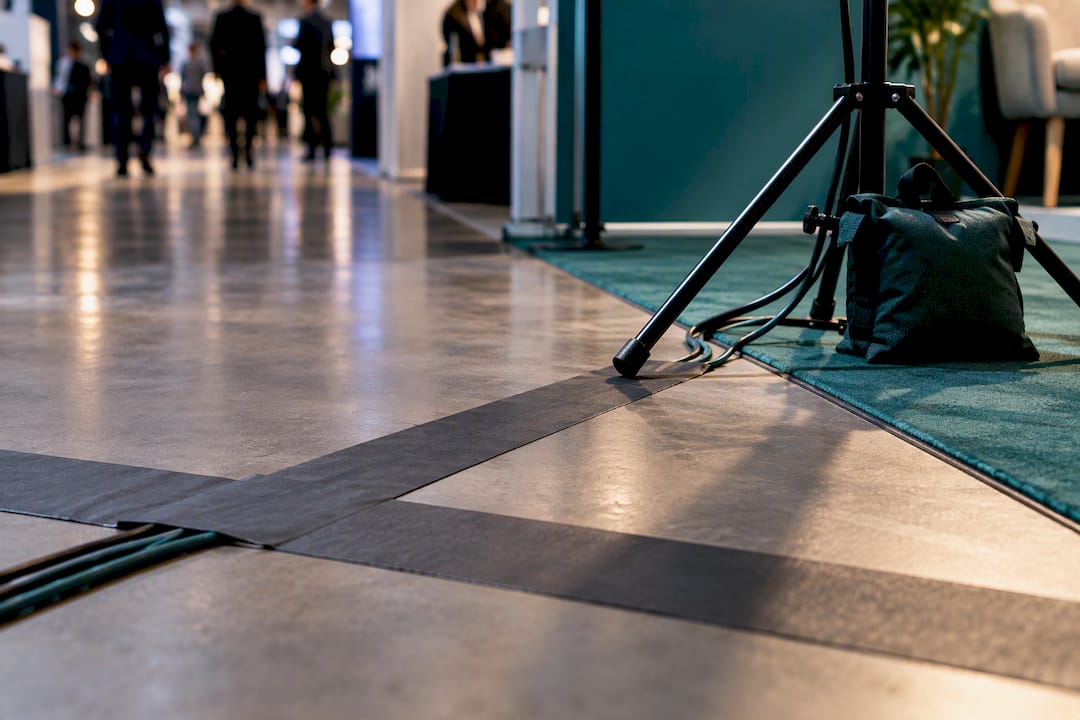 Taped booth cable beside weighted lighting stand