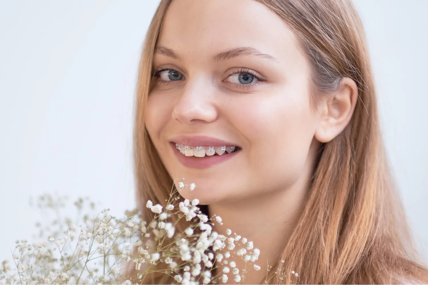 A woman holding a bunch of baby's breath flowers.