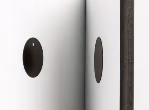 a round magnet on a white wall with a foam photo tile with another circular magnet on it about to touch