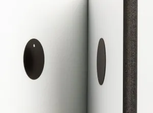 a round magnet on a white wall with a foam photo tile with another circular magnet on it about to touch